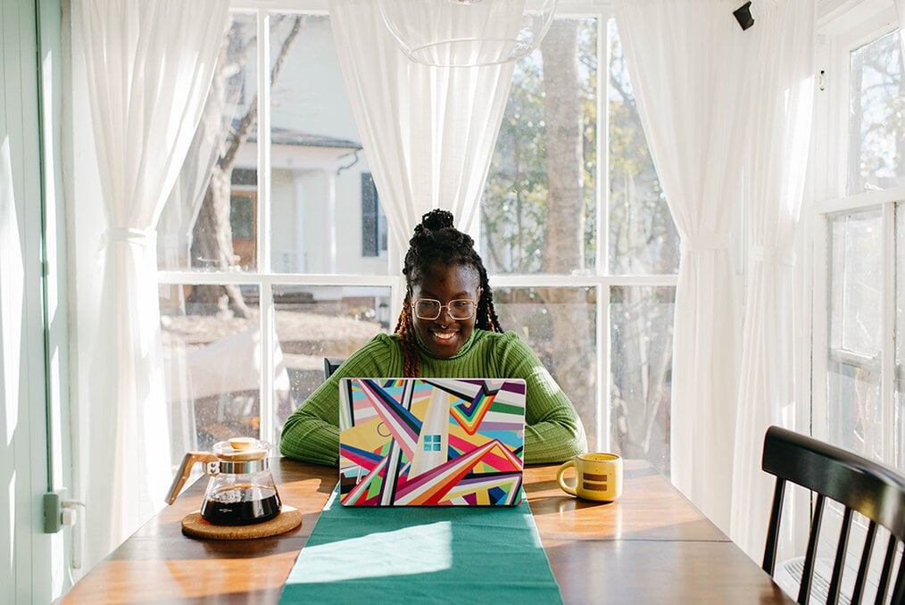 A person drinking coffee and working on their computer